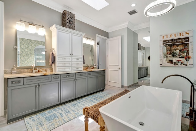 506 Corsair Dr, North Palm Beach, FL 33408 - full bathroom with double vanity, ornamental molding, a freestanding tub, and a skylight