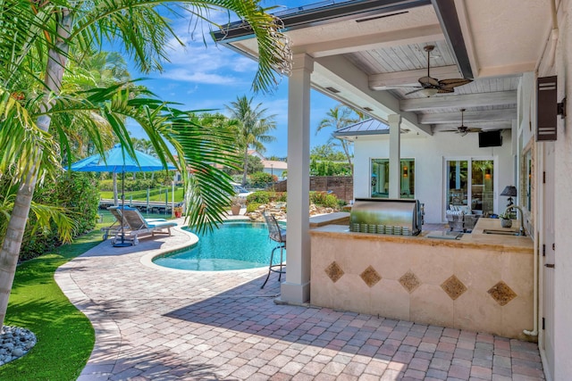 506 Corsair Dr, North Palm Beach, FL 33408 - outdoor pool featuring a patio area, a fenced backyard, a ceiling fan, area for grilling, and a sink