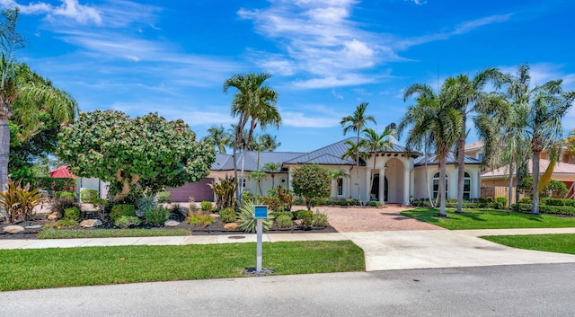 506 Corsair Dr, North Palm Beach, FL 33408 - view of front of home featuring stucco siding, decorative driveway, and a front yard