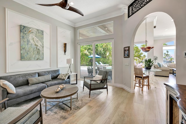 506 Corsair Dr, North Palm Beach, FL 33408 - living room with arched walkways, crown molding, a ceiling fan, light wood-style floors, and baseboards