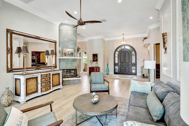 506 Corsair Dr, North Palm Beach, FL 33408 - living area with a ceiling fan, a fireplace, light wood-style flooring, crown molding, and recessed lighting