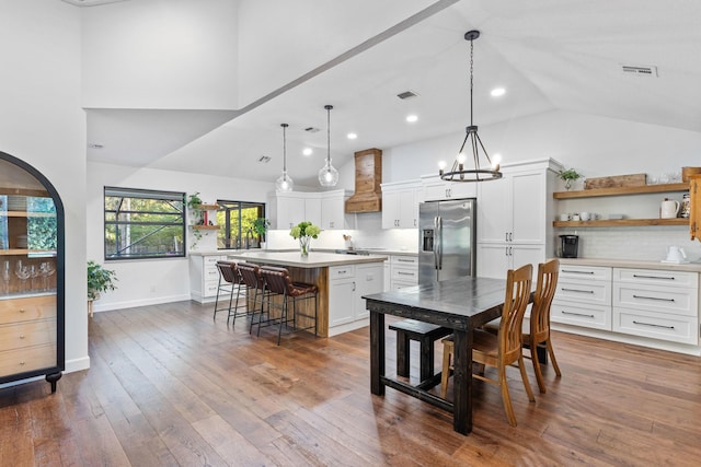 9544 Mockingbird Trl, Jupiter, FL 33478 - kitchen with stainless steel fridge with ice dispenser, open shelves, custom range hood, light countertops, and high vaulted ceiling