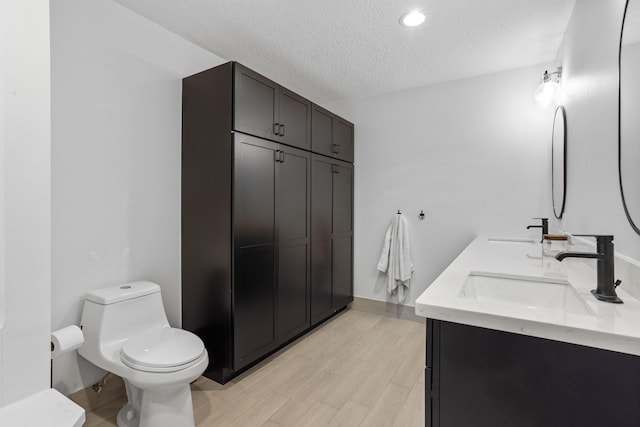 9544 Mockingbird Trl, Jupiter, FL 33478 - full bathroom featuring toilet, a textured ceiling, wood finished floors, and double vanity