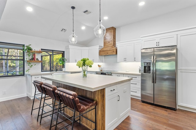 9544 Mockingbird Trl, Jupiter, FL 33478 - kitchen featuring stainless steel fridge, custom exhaust hood, decorative backsplash, light countertops, and open shelves