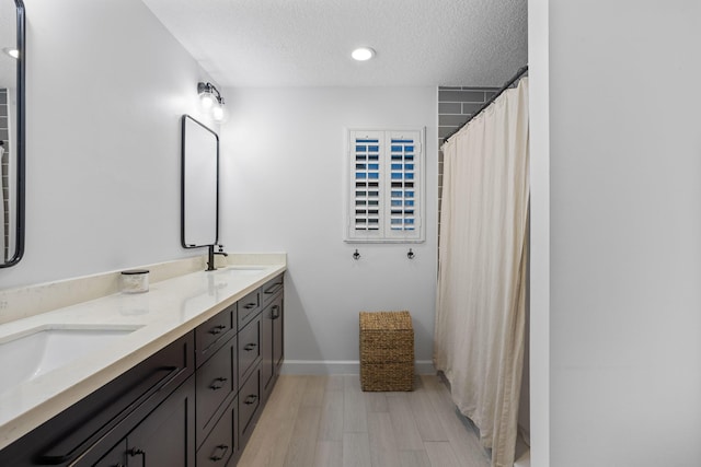 9544 Mockingbird Trl, Jupiter, FL 33478 - bathroom with wood finished floors, a textured ceiling, double vanity, baseboards, and curtained shower