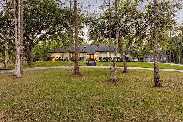 9544 Mockingbird Trl, Jupiter, FL 33478 - view of front of house featuring curved driveway and a front yard