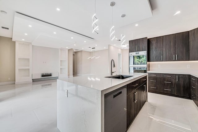 2929 Lorene Dr, Palm Springs, FL 33461 - kitchen with modern cabinets, a sink, stainless steel double oven, a center island with sink, and decorative light fixtures
