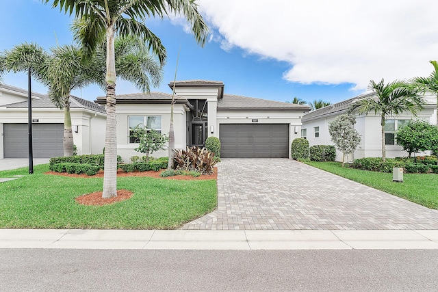 9319 Silver Shores Ln, Boynton Beach, FL 33473 - prairie-style house with an attached garage, decorative driveway, a front lawn, and stucco siding