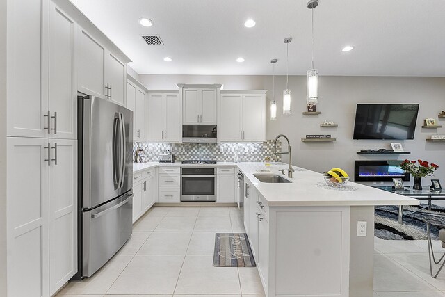9319 Silver Shores Ln, Boynton Beach, FL 33473 - kitchen featuring stainless steel appliances, a sink, backsplash, light countertops, and light tile patterned floors