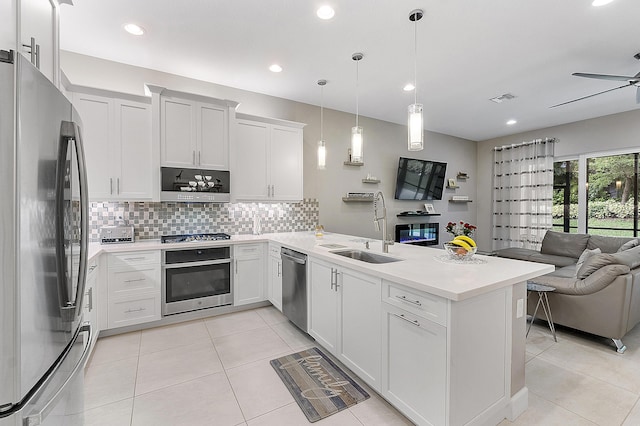 9319 Silver Shores Ln, Boynton Beach, FL 33473 - kitchen featuring appliances with stainless steel finishes, open floor plan, a sink, a peninsula, and decorative backsplash