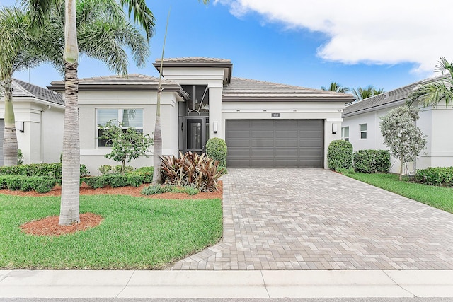 9319 Silver Shores Ln, Boynton Beach, FL 33473 - view of front facade featuring an attached garage, decorative driveway, a front yard, stucco siding, and a tiled roof