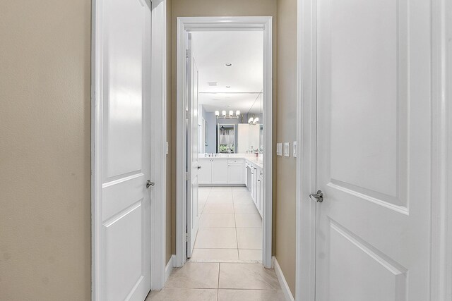9319 Silver Shores Ln, Boynton Beach, FL 33473 - hall with light tile patterned floors, a chandelier, and baseboards