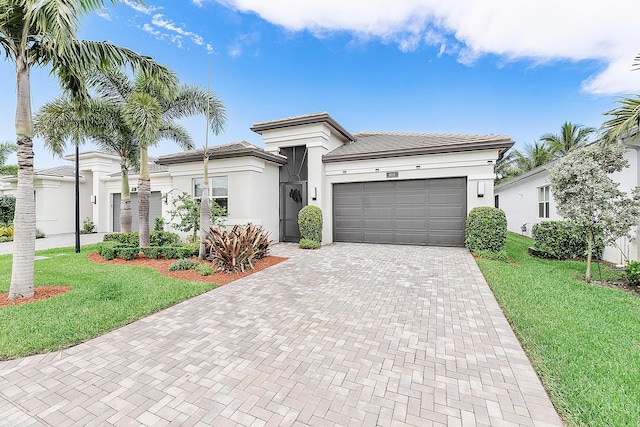 9319 Silver Shores Ln, Boynton Beach, FL 33473 - view of front of property with decorative driveway, an attached garage, a tile roof, a front lawn, and stucco siding