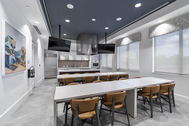 9319 Silver Shores Ln, Boynton Beach, FL 33473 - kitchen with appliances with stainless steel finishes, baseboards, modern cabinets, a kitchen island, and range hood