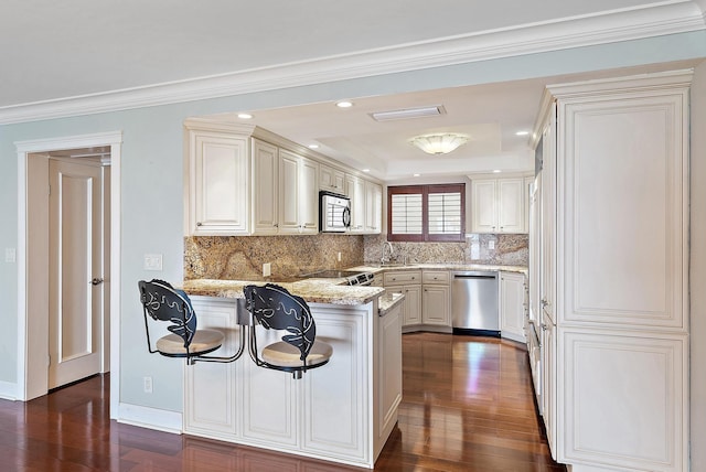 350 Beach Rd Unit 503, Tequesta, FL 33469 - kitchen with stainless steel appliances, tasteful backsplash, a peninsula, dark wood-style floors, and light stone countertops
