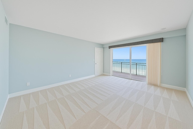 350 Beach Rd Unit 503, Tequesta, FL 33469 - spare room with a water view, baseboards, and light carpet