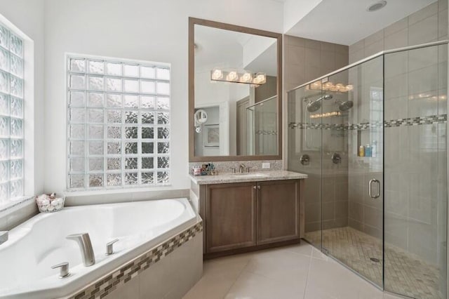 bathroom featuring a stall shower, a garden tub, tile patterned flooring, and vanity
