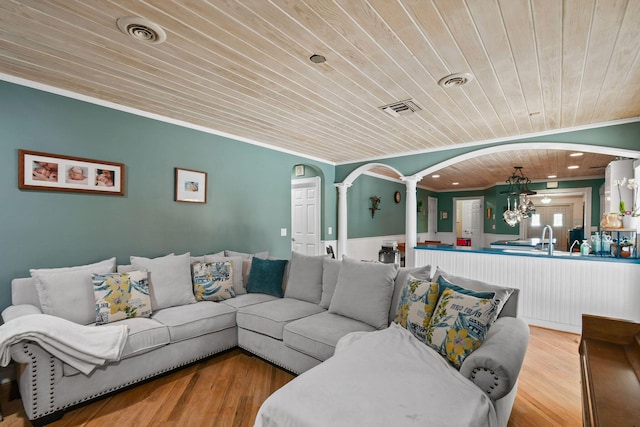 11151 88th Rd N, Palm Beach Gardens, FL 33412 - living room with decorative columns, wooden ceiling, ornamental molding, arched walkways, and wood finished floors