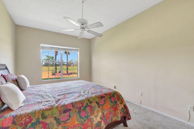 bedroom with carpet floors, a ceiling fan, baseboards, and a textured ceiling