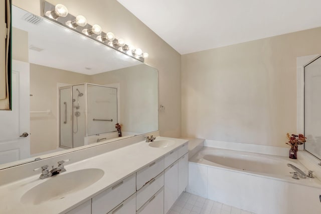 bathroom with a garden tub, a shower stall, tile patterned floors, and double vanity