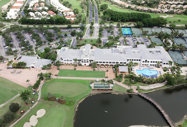 aerial view of property's location featuring a nearby body of water, a golf course, and a pool
