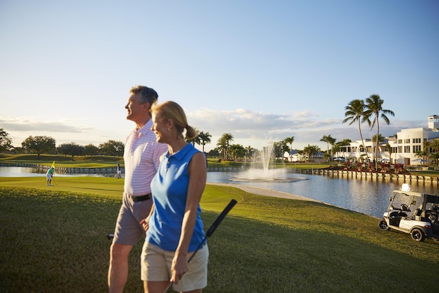 surrounding community featuring a water view and a lawn