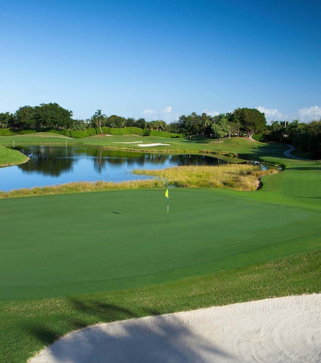 surrounding community with view of golf course, a water view, and view of scattered trees