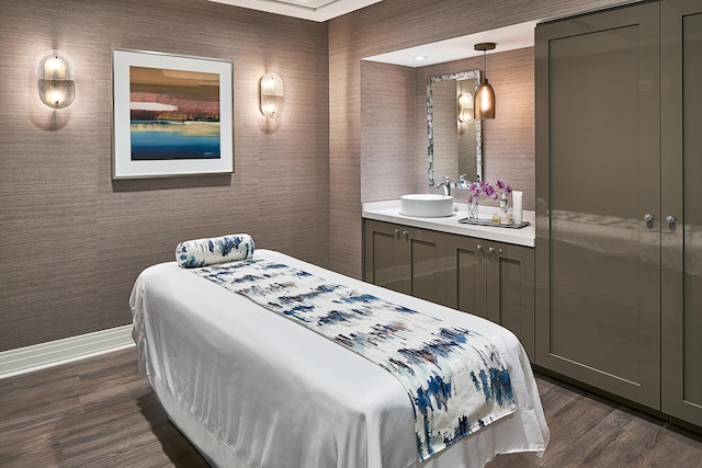 bedroom with a sink, dark wood finished floors, and baseboards