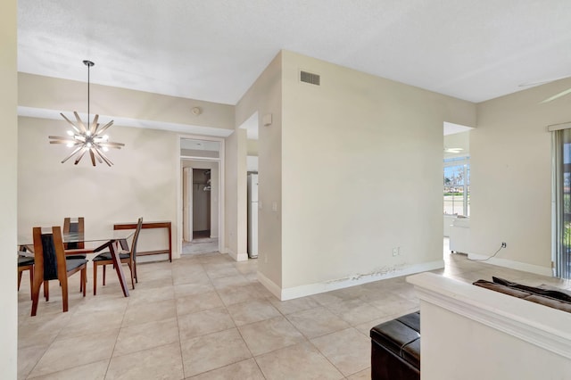 dining space with a chandelier, light tile patterned floors, and baseboards
