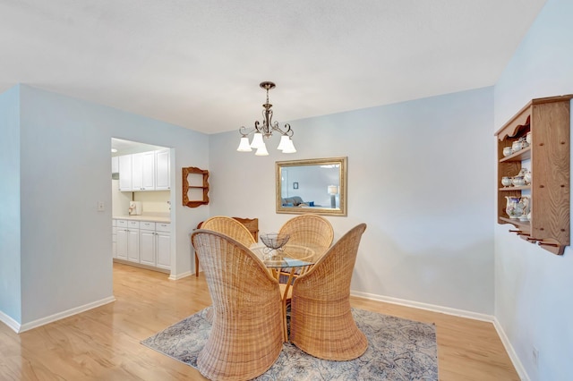 410 High Point Dr Unit C, Delray Beach, FL 33445 - dining space with light wood-style flooring, a chandelier, and baseboards