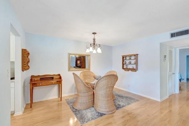 410 High Point Dr Unit C, Delray Beach, FL 33445 - dining area featuring wood finished floors, a chandelier, and baseboards