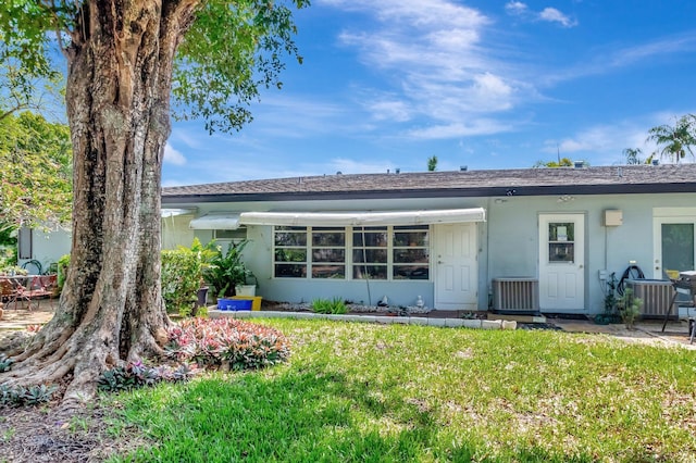 410 High Point Dr Unit C, Delray Beach, FL 33445 - rear view of house with a yard, stucco siding, and central air condition unit