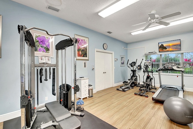 410 High Point Dr Unit C, Delray Beach, FL 33445 - gym featuring a ceiling fan, a textured ceiling, wood finished floors, and baseboards