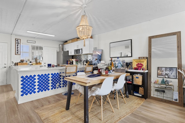 dining space with a chandelier and light wood-style flooring
