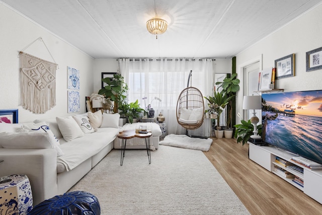 living area featuring wood finished floors and crown molding