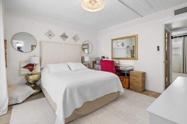 bedroom with light wood-type flooring and baseboards