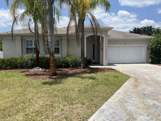 6110 46th Ln, Vero Beach, FL 32967 - ranch-style home featuring stucco siding, a garage, decorative driveway, and a front lawn