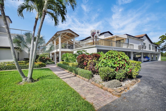 730 Greensward Ct Unit 107-J, Delray Beach, FL 33445 - view of front of home featuring a front yard, covered parking, and a balcony