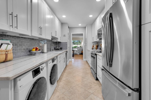 730 Greensward Ct Unit 107-J, Delray Beach, FL 33445 - kitchen with stainless steel appliances, recessed lighting, decorative backsplash, washer and dryer, and light tile patterned floors