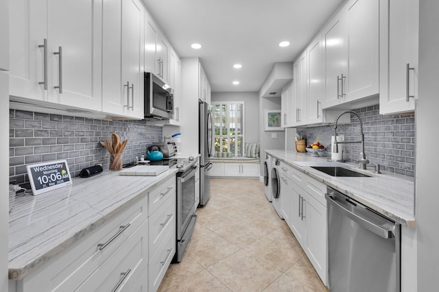 730 Greensward Ct Unit 107-J, Delray Beach, FL 33445 - kitchen with stainless steel appliances, a sink, separate washer and dryer, recessed lighting, and light tile patterned floors