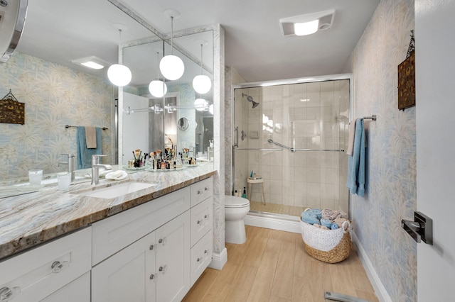 730 Greensward Ct Unit 107-J, Delray Beach, FL 33445 - full bath featuring vanity, toilet, a stall shower, wood finished floors, and wallpapered walls
