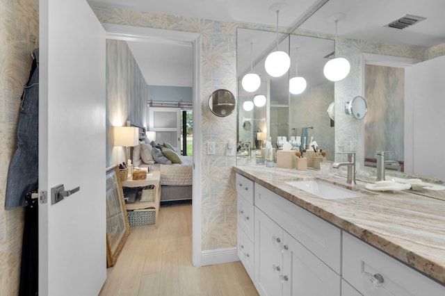 730 Greensward Ct Unit 107-J, Delray Beach, FL 33445 - bathroom with ensuite bath, vanity, wallpapered walls, and wood finished floors
