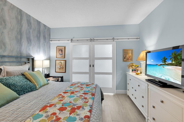 730 Greensward Ct Unit 107-J, Delray Beach, FL 33445 - bedroom with light wood finished floors, baseboards, and a textured ceiling