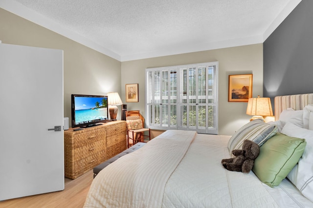 730 Greensward Ct Unit 107-J, Delray Beach, FL 33445 - bedroom featuring wood finished floors and a textured ceiling