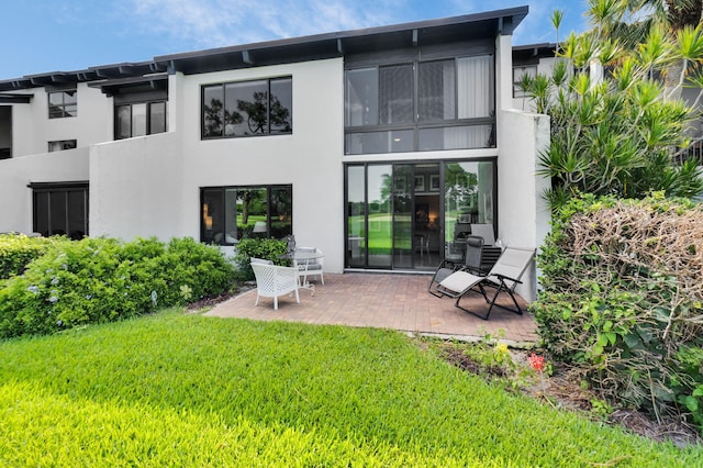 730 Greensward Ct Unit 107-J, Delray Beach, FL 33445 - back of property featuring stucco siding, a yard, and a patio area