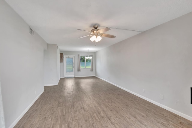 2161 NE 42nd Ct Unit 116, Lighthouse Point, FL 33064 - spare room featuring ceiling fan, wood finished floors, baseboards, and a chandelier