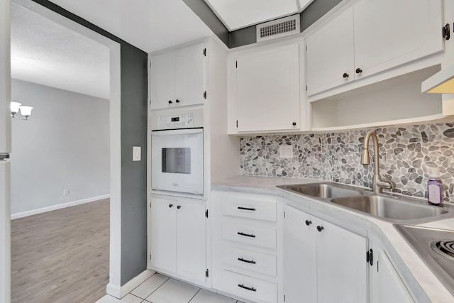 2161 NE 42nd Ct Unit 116, Lighthouse Point, FL 33064 - kitchen featuring white oven, a sink, backsplash, open shelves, and light countertops