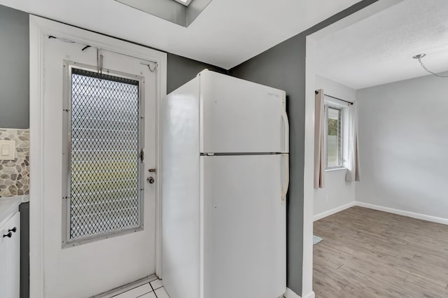 2161 NE 42nd Ct Unit 116, Lighthouse Point, FL 33064 - kitchen featuring freestanding refrigerator, light wood finished floors, and baseboards
