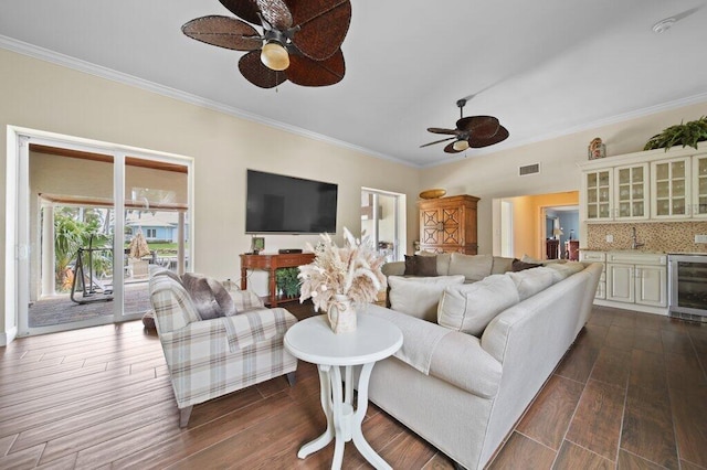 16 E High Point Rd, Sewalls Point, FL 34996 - living area with wine cooler, a ceiling fan, ornamental molding, and dark wood-style flooring