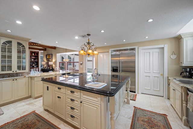 2 Firestone Cir, West Palm Beach, FL 33401 - kitchen featuring cream cabinets, stainless steel appliances, a chandelier, a kitchen island with sink, and recessed lighting